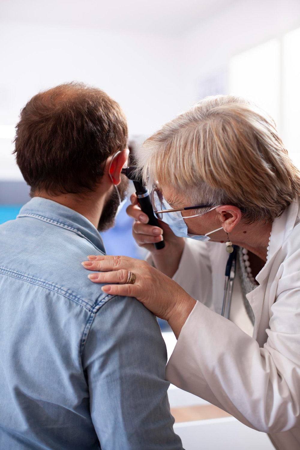 Dr. Aussem examining a patient's ear during a hearing check