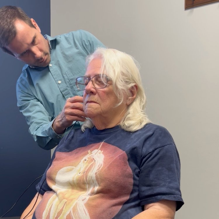 Dr. Aussem carefully fitting a device on a returning patient
