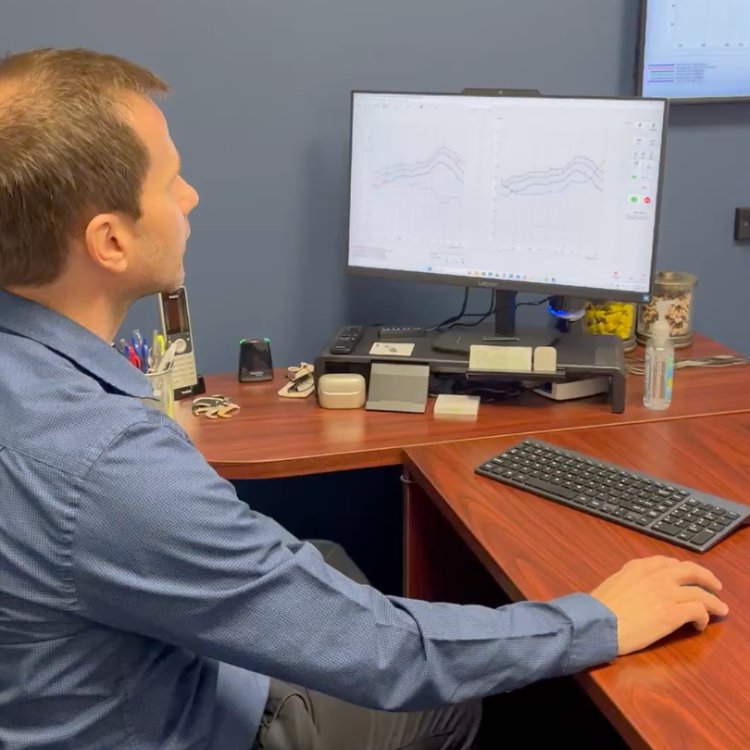 Dr. Aussem reviewing a patient's hearing test results on screen at his desk