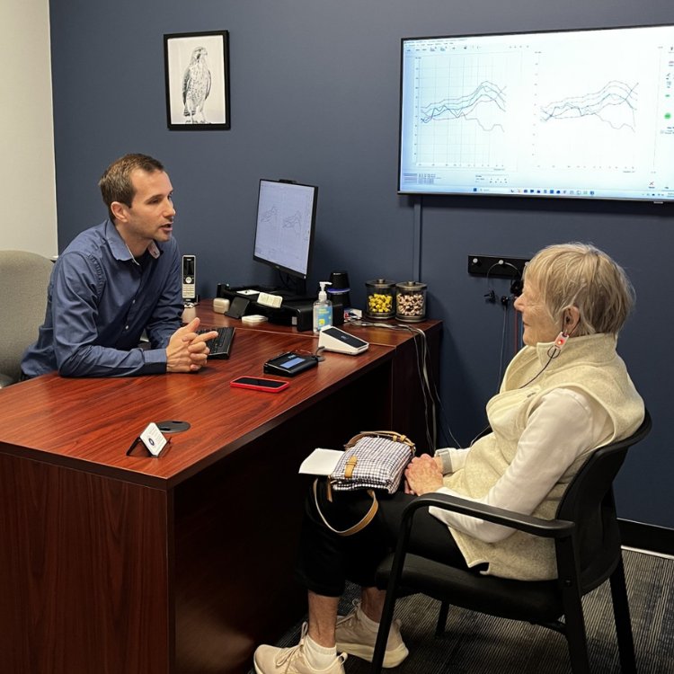Dr. Aussem reviewing a patient's hearing test results with them at his desk